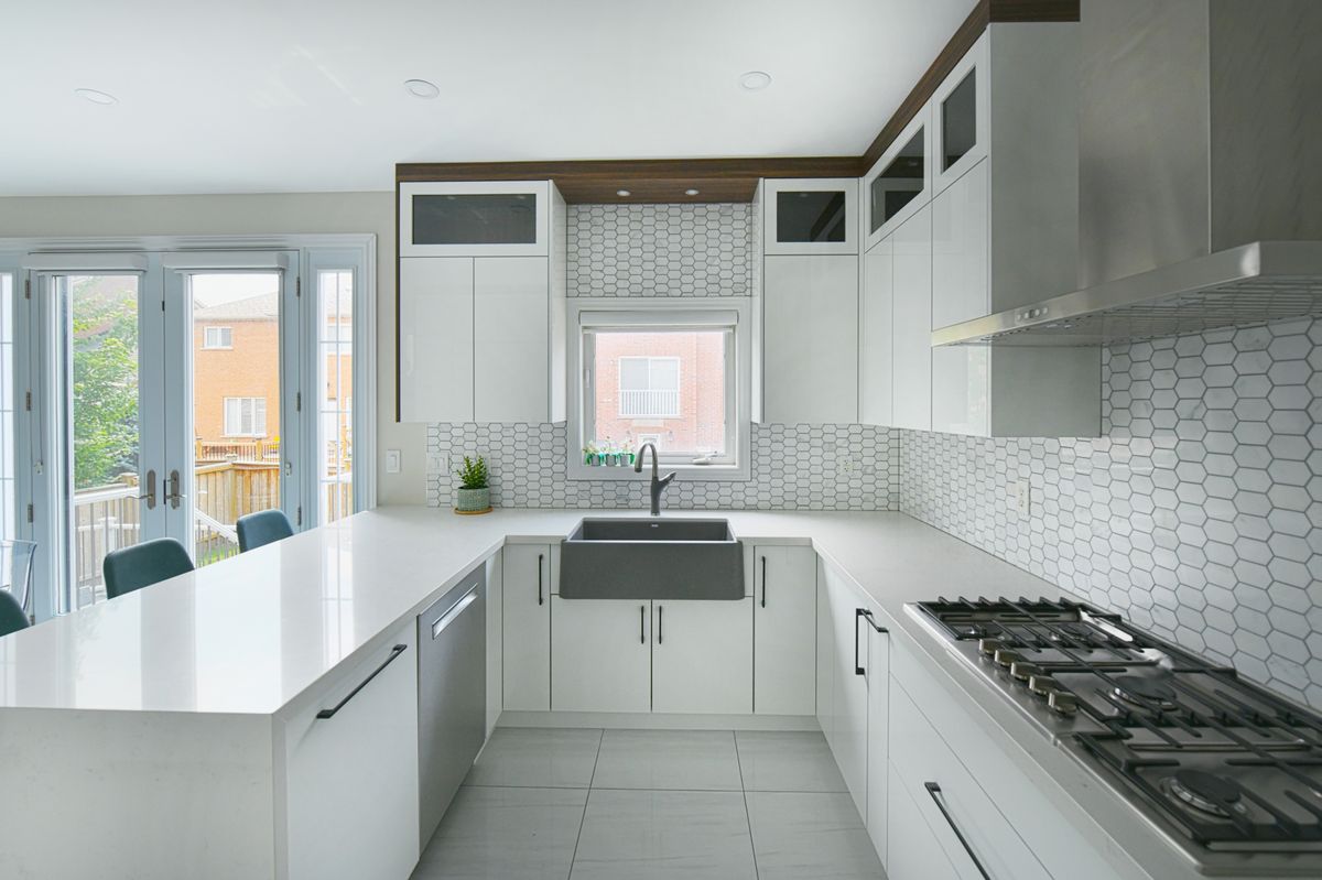 Cocina contemporánea blanca con isla y frente de gas